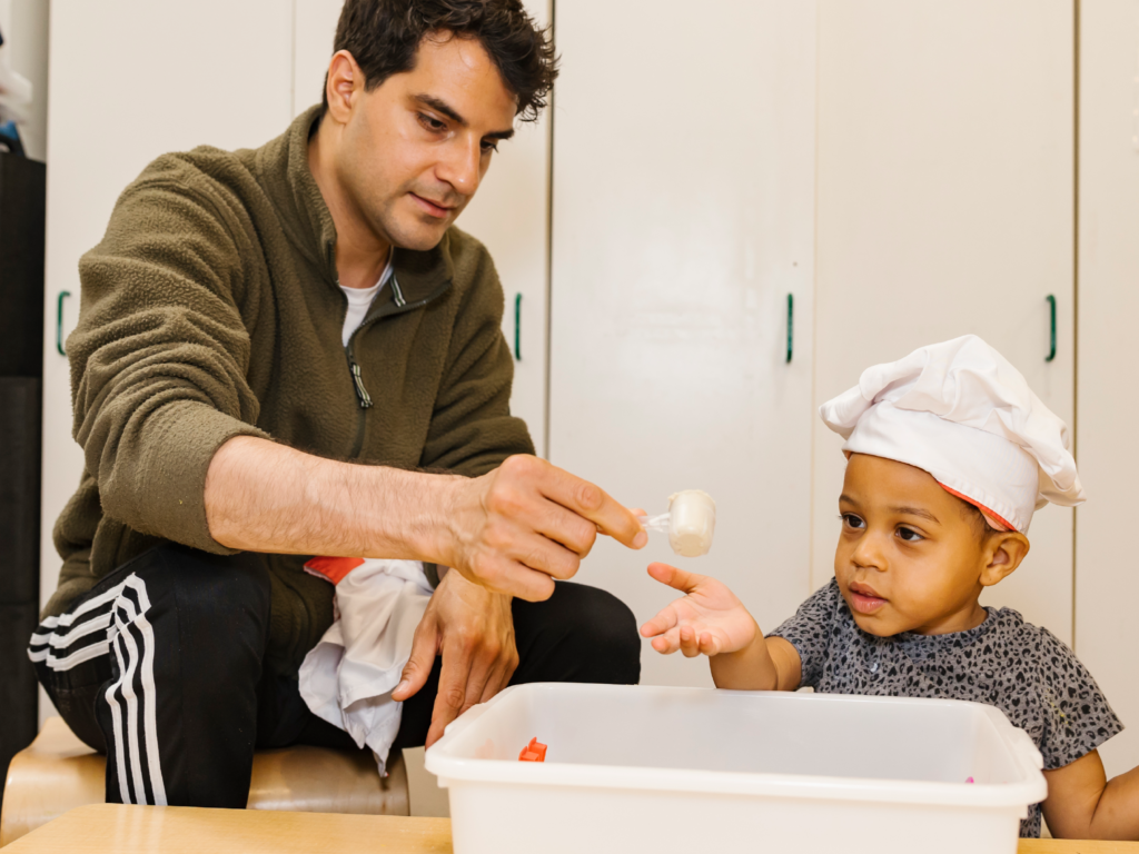 teacher and child interacting at craft table
